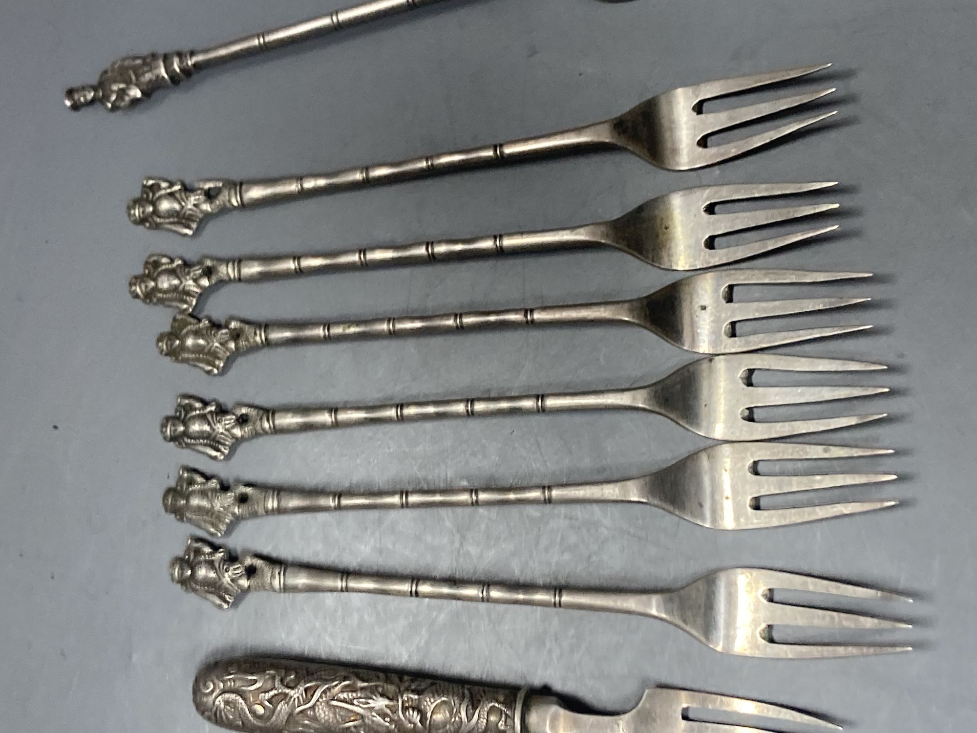 A group of assorted Chinese white metal spoons and forks, including set of six teaspoons and ten small items of English silver.